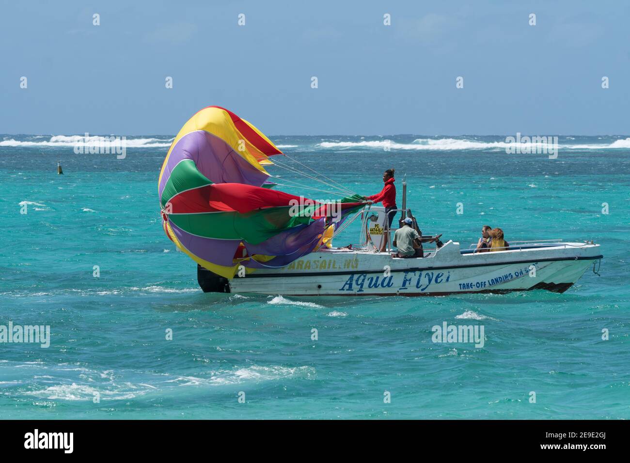 Bateau de parachute ascensionnel avec parachute relâché pour une voile sur Eau de mer bleu turquoise à l'île Maurice et les gens à bord Banque D'Images