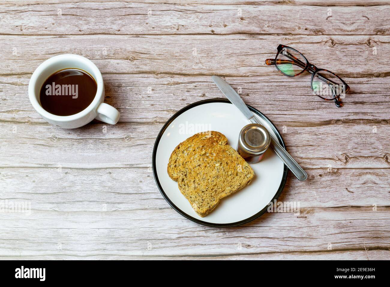 Toasts et confiture sur une assiette à côté d'un café sur une table en bois pour représenter l'heure du petit déjeuner Banque D'Images