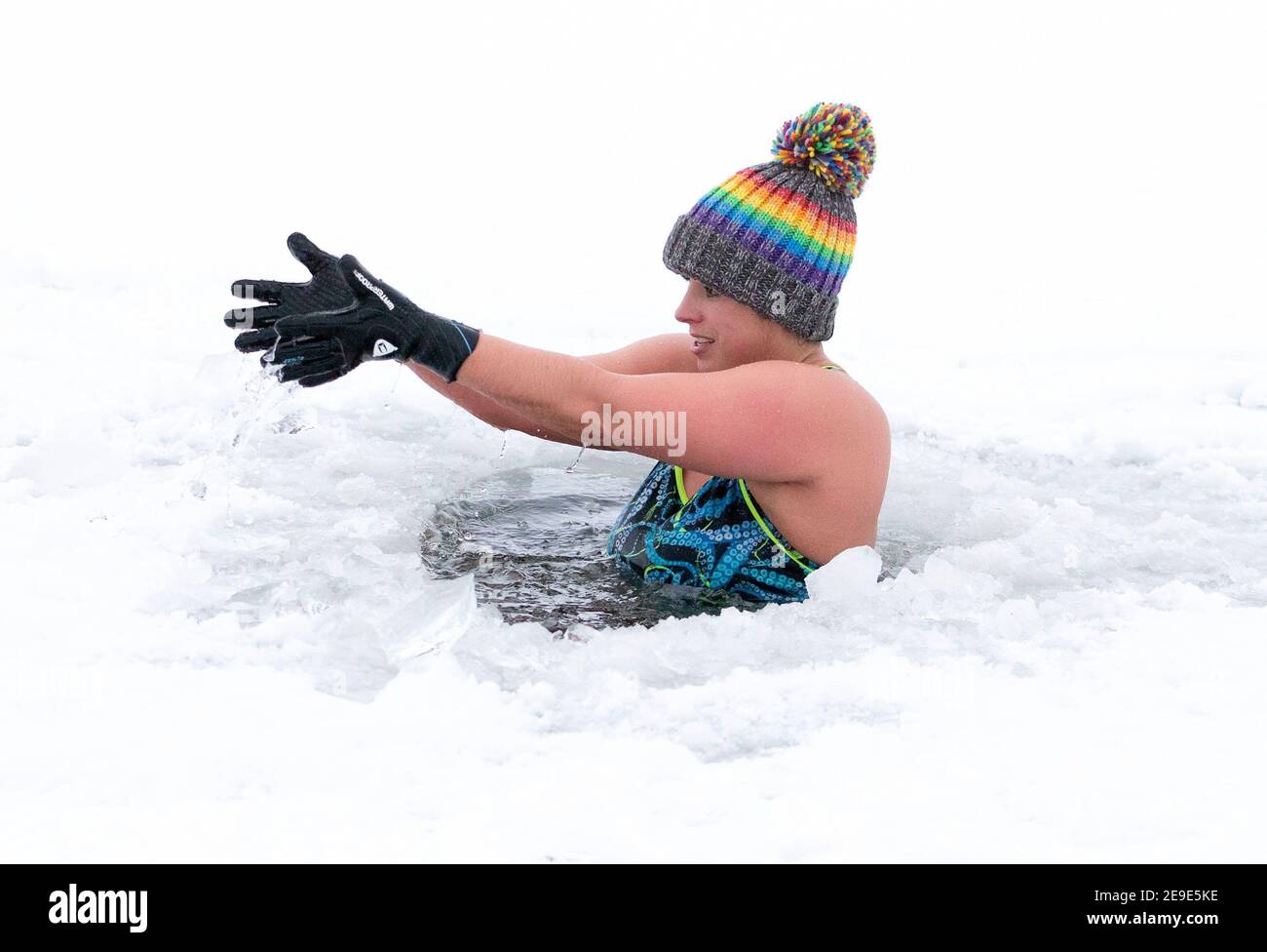 RETRANSMETTANT LE NOM RECTIFIANT DU LOCH INCH À LOCH INSH. LÉGENDE JUSTE AU-DESSOUS d'Alice Goodridge, de Newtonmore, plonge à travers un trou dans la glace dans le Loch Insh, dans le parc national de Cairngorms. Date de la photo : jeudi 4 février 2021. Banque D'Images