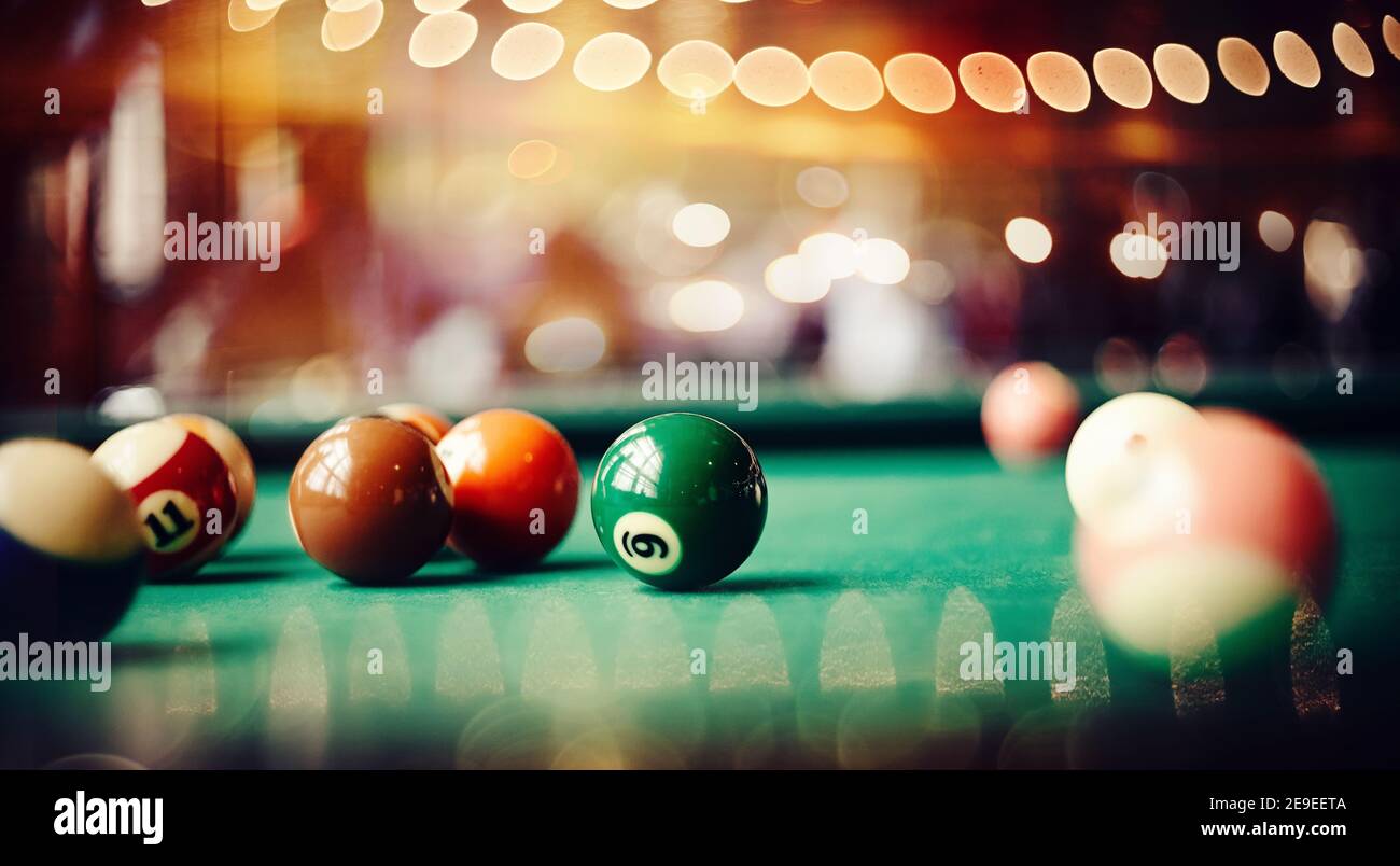 Boules de billard colorées sur une table de billard verte. Jeu de billard. Boule de billard avec le numéro neuf. Banque D'Images