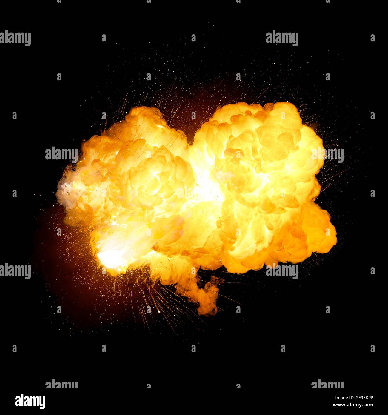 Explosion d'une bombe très lumineuse, couleur orange avec étincelles et fumée isolée sur fond noir Banque D'Images
