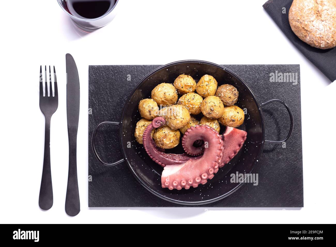 brocher les tentacules de poulpe avec les pommes de terre sur une plaque à poêle sur fond blanc. Vue de dessus. Banque D'Images