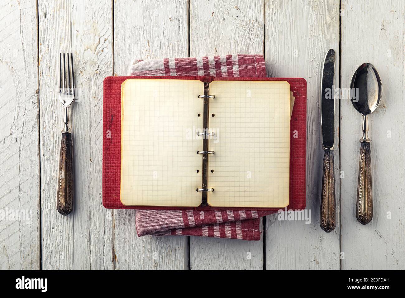 Livre de cuisine vide vintage sur table en bois avec vieux couverts Banque D'Images