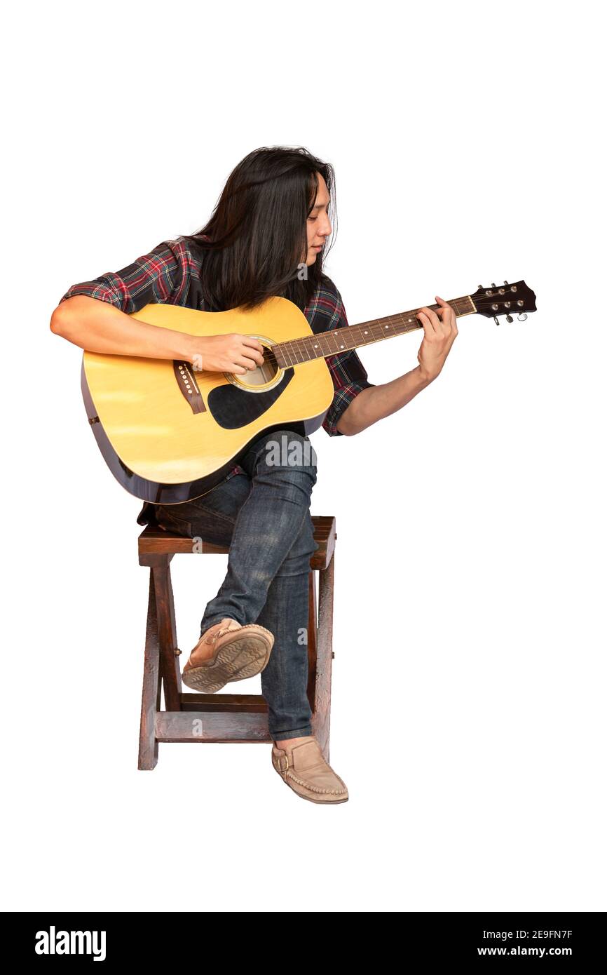 Portrait beau jeune homme guitariste avec de longs cheveux assis et jouant de la guitare acoustique. Homme asiatique à poil long jouant de la guitare acoustique isolé sur W Banque D'Images