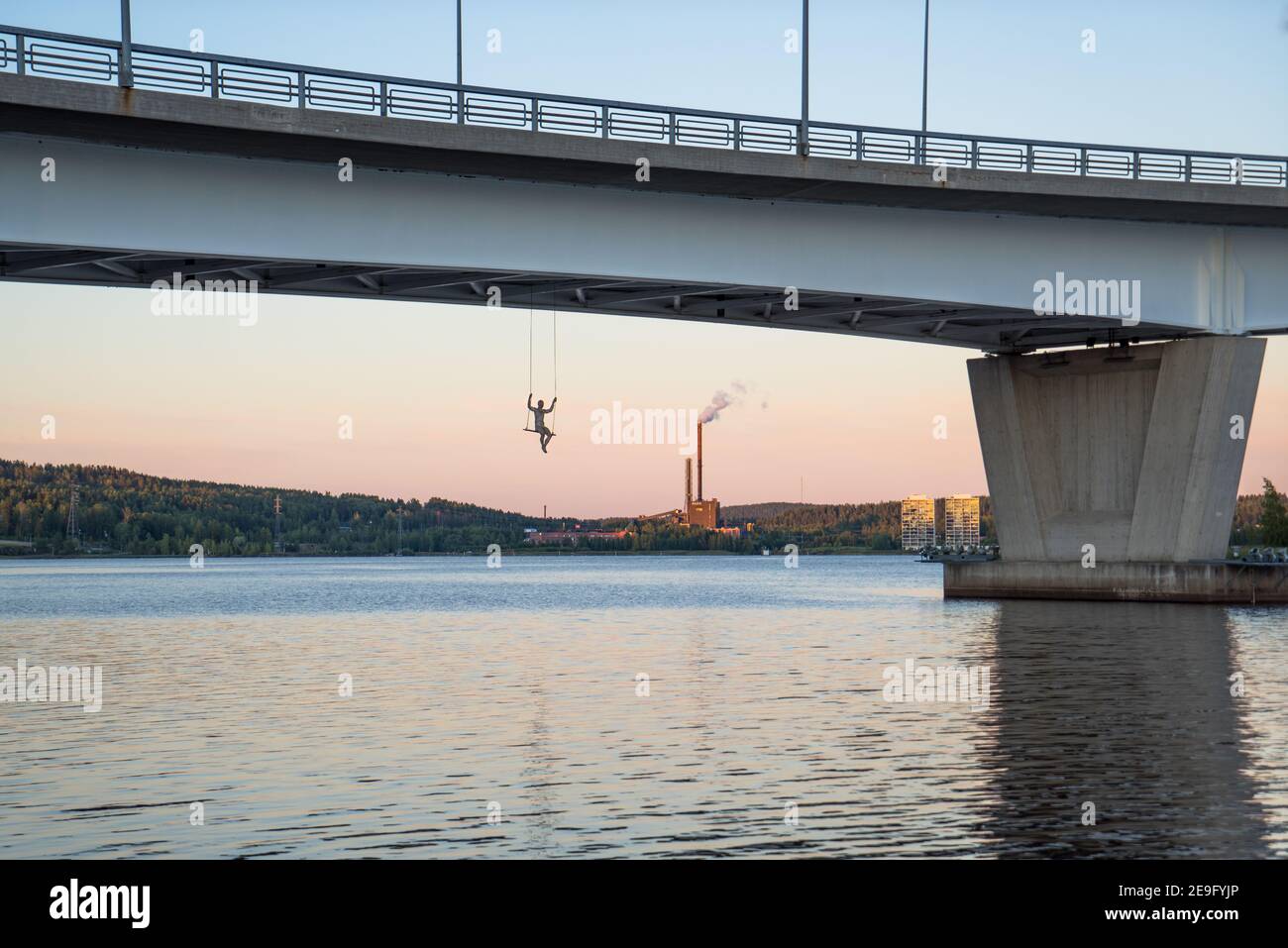 Pont Kuokkalan silta à Jyväskylä, en Finlande, au lac Jyväsjärvi. Dangereux, l'adrénaline balancer avec une personne sous le pont sur un beau coucher de soleil de soirée Banque D'Images