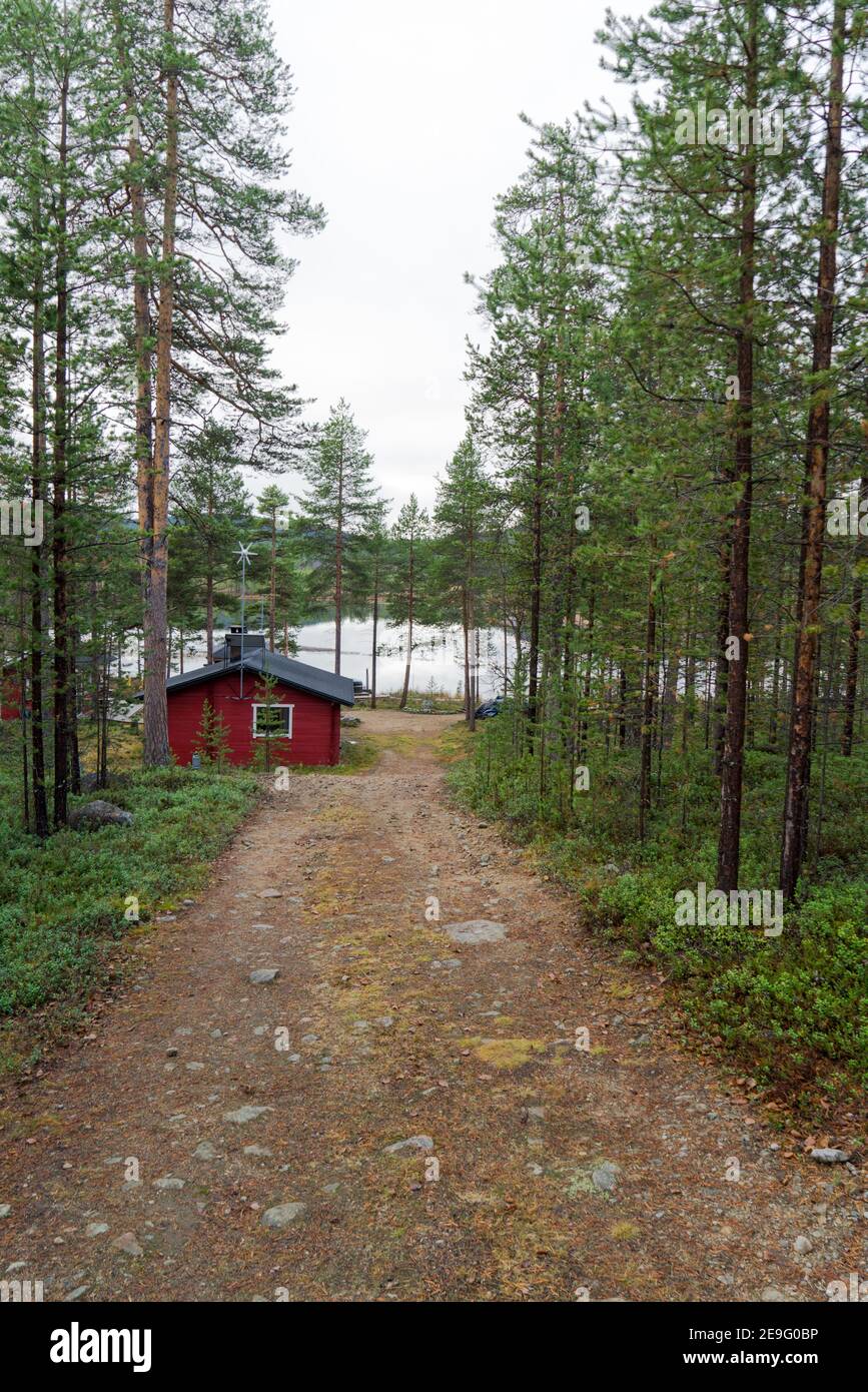 Chemin mène à la belle idyllique cottage en bois rouge dans la nature d'arrivée. Chalet isolé à Inari, Laponie, Finlande pour des vacances romantiques Banque D'Images