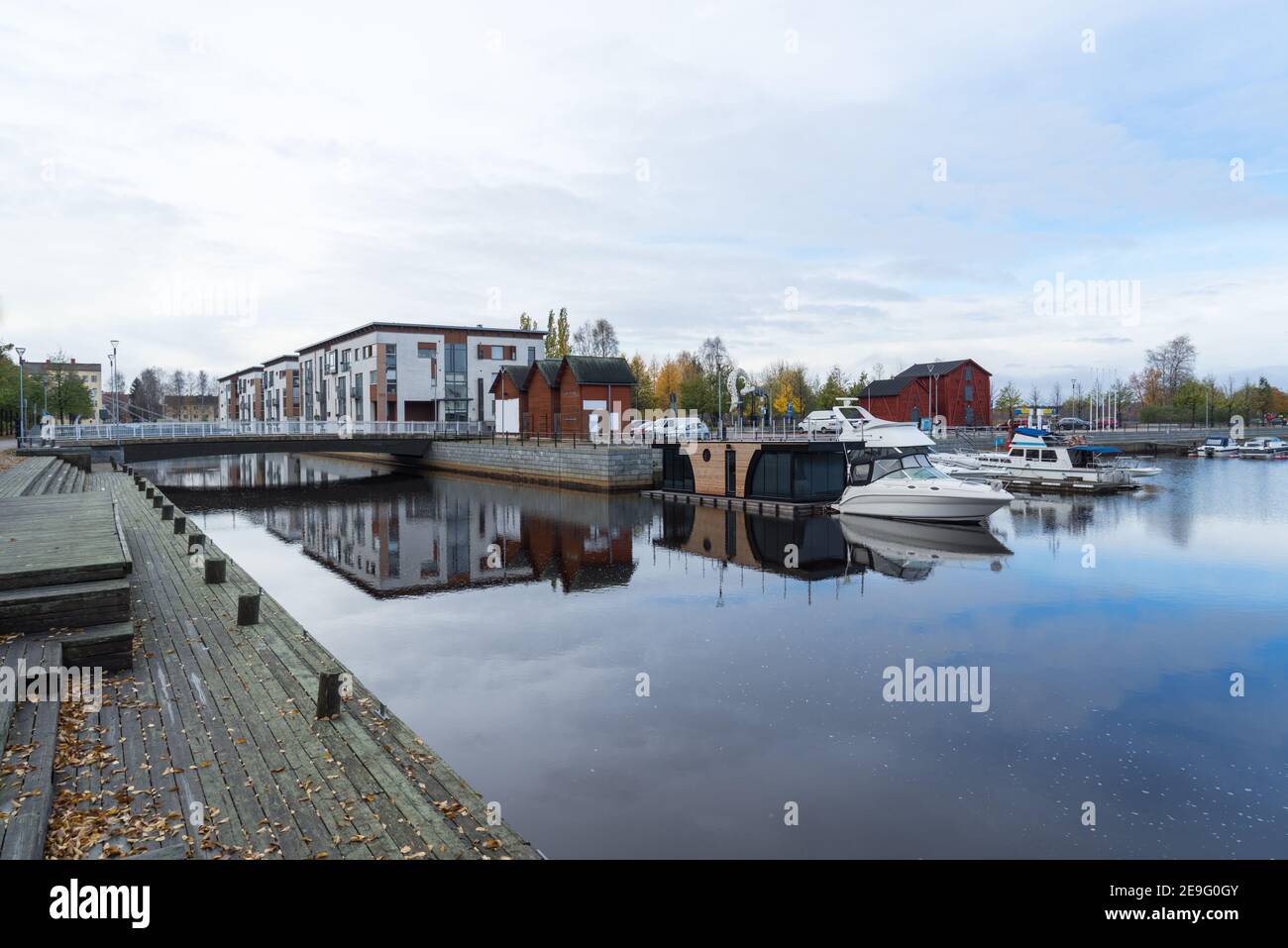 Pont à Kiikeli à Oulu avec des appartements modernes, propres et chers. Jetée en bois avec réflexion dans l'eau du canal. Péniche et navires dans le port Banque D'Images
