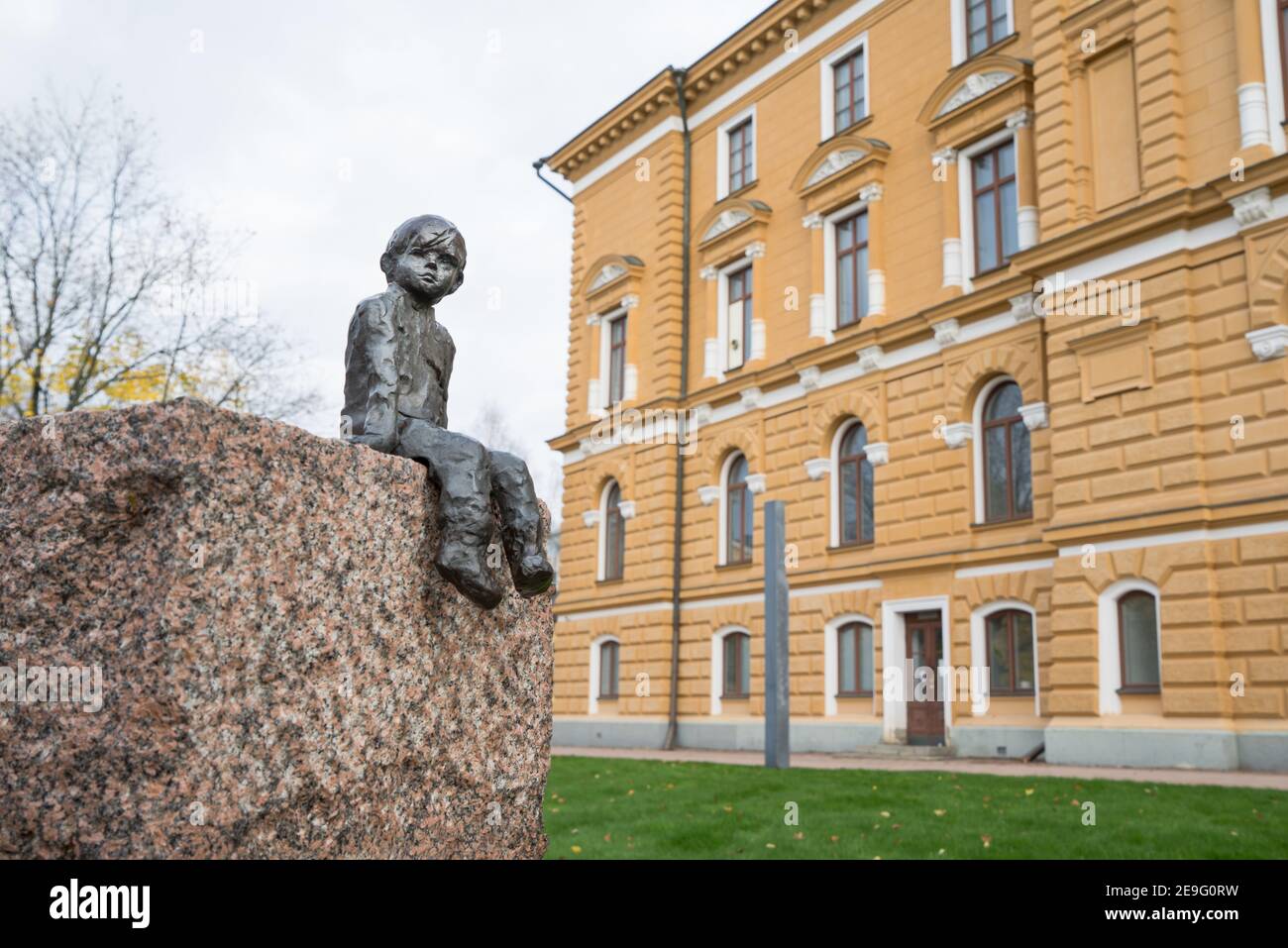 OULU, FINLANDE - 12 octobre 2020 : gros plan de la sculpture en bronze du jeune garçon d'arrivée, assis devant l'hôtel de ville sur du granit souriant au passage de Tim Banque D'Images