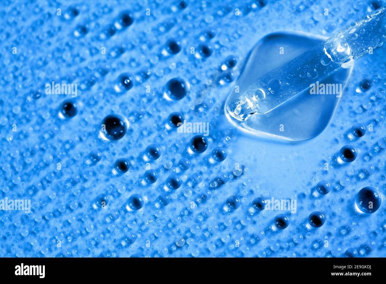 fond d'eau bleu avec flacon de cosmétiques en verre et compte-gouttes pour médicaments. couche hydratante à plat. Banque D'Images