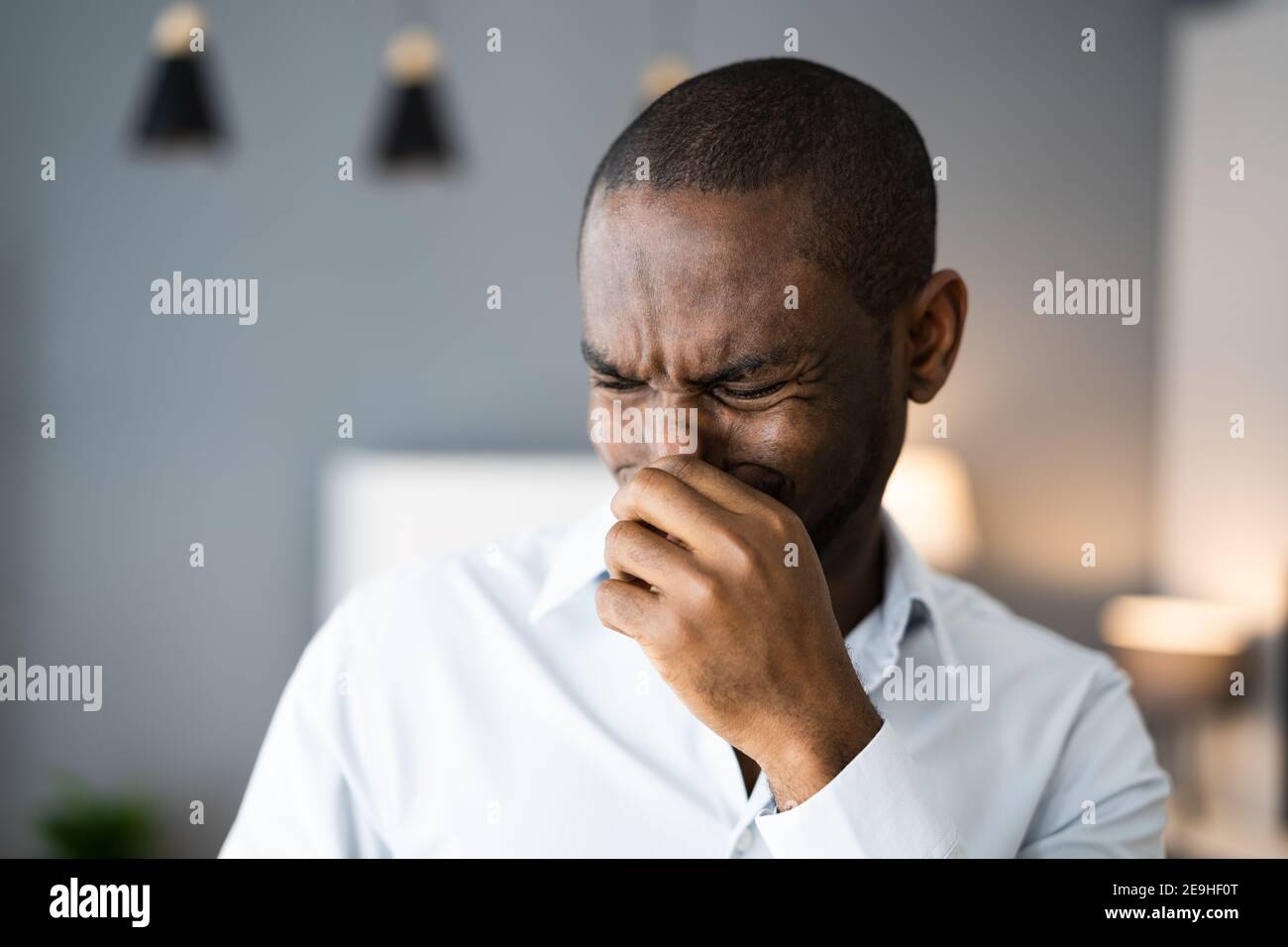 Homme couvrant son nez de mauvaise odeur à l'intérieur de la maison Banque D'Images