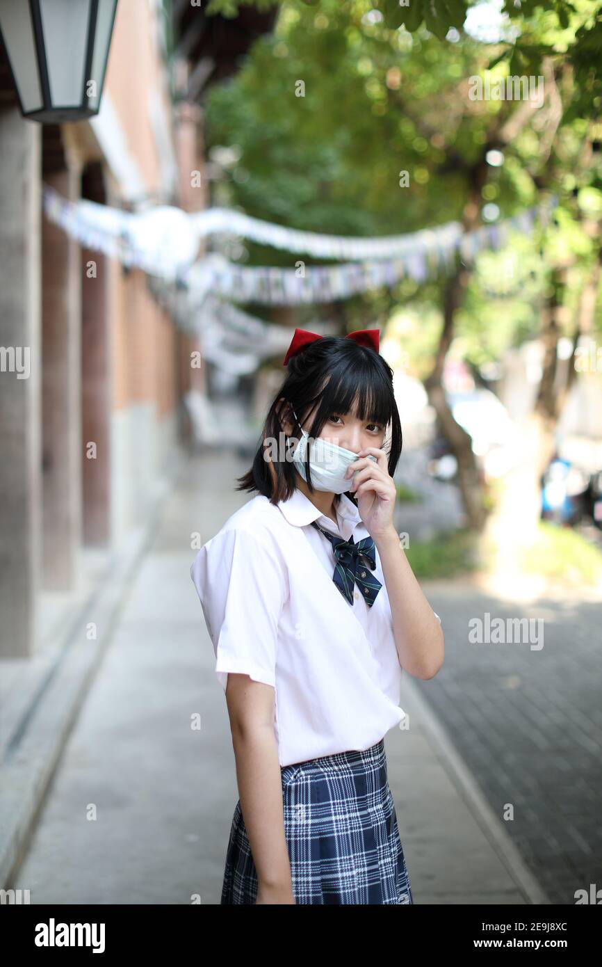 École asiatique fille avec masque Banque D'Images