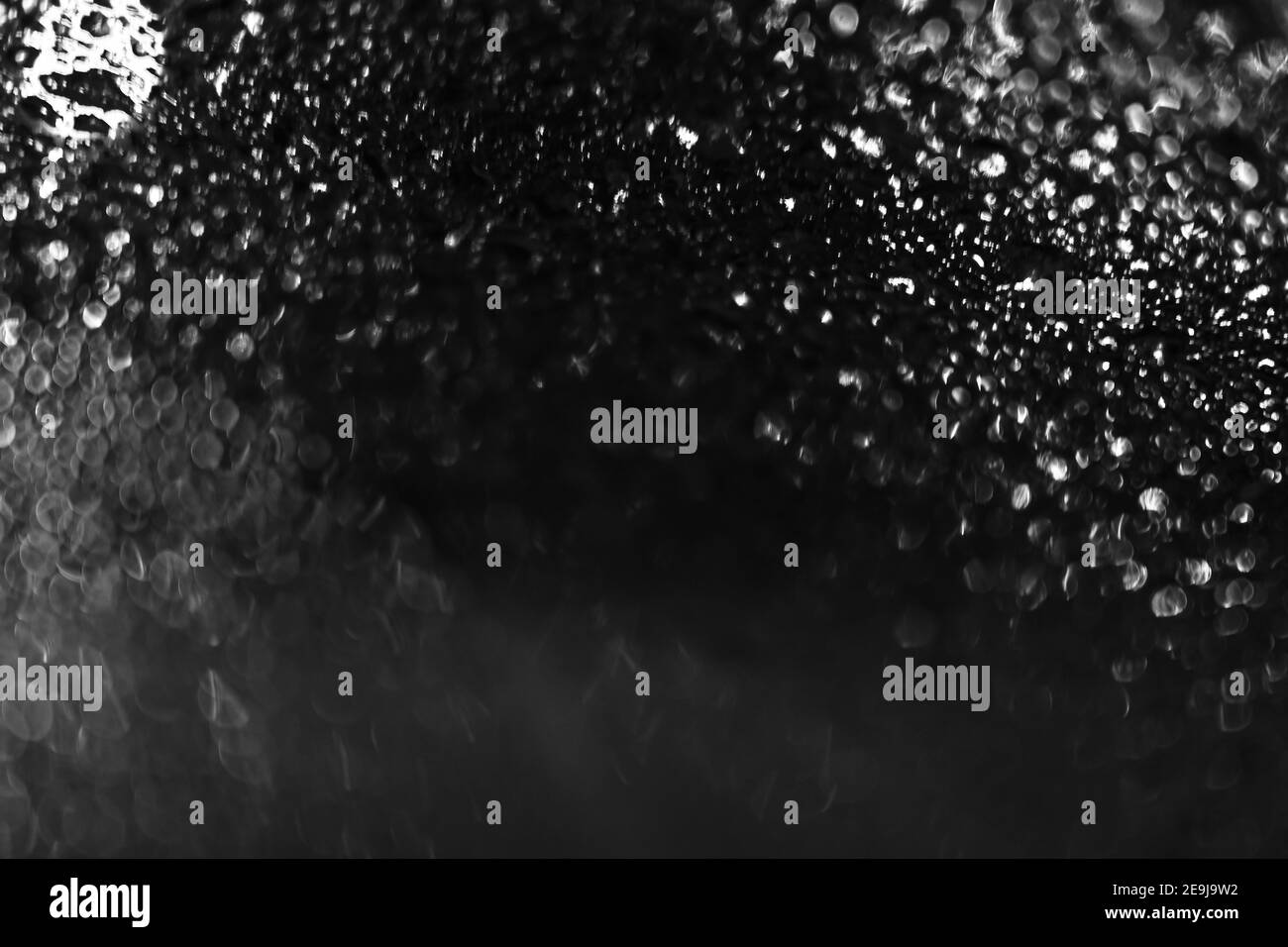 Verre noir avec texture d'arrière-plan gouttes de pluie vue horizontale du dessus, pluie sur fond de verre, bokeh de lumière abstrait et gouttes de flou artistique, eau claire sur Banque D'Images