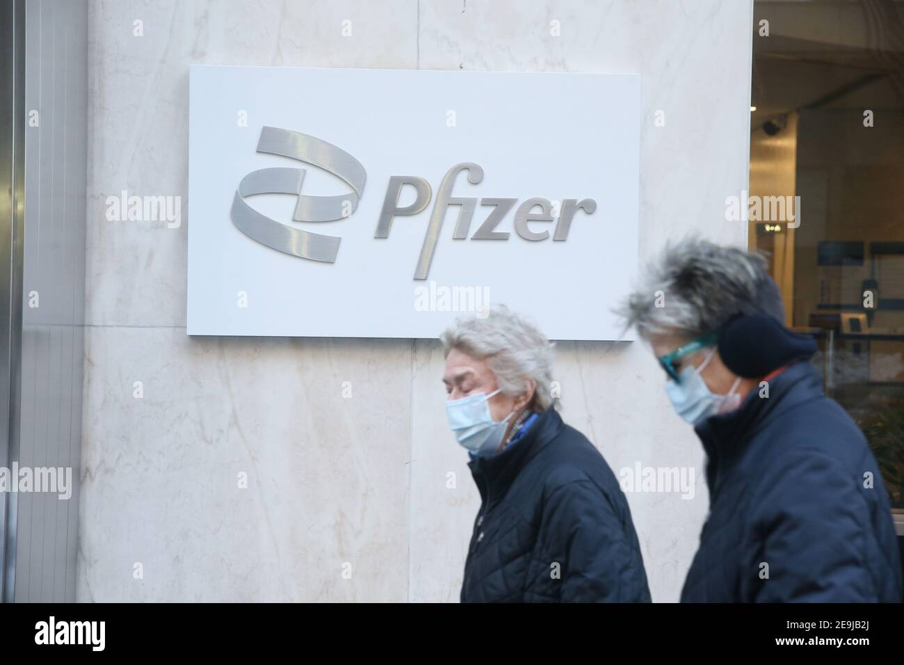 New York City, NY États-Unis les femmes âgées marchent à travers.Le panneau siège mondial de Pfizer sur la 42e rue à Manhattan Banque D'Images