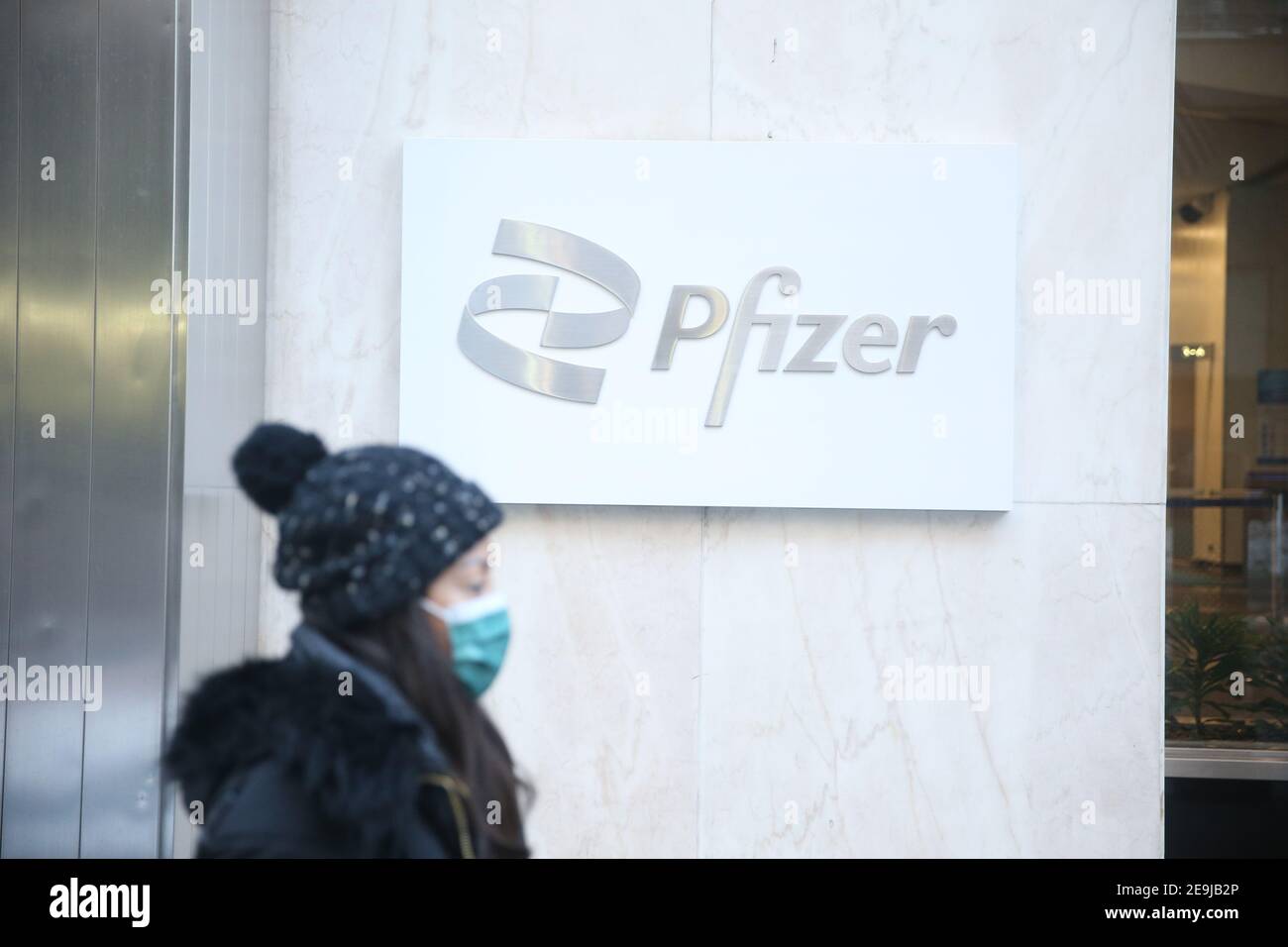New York City, NY USA une femme passe devant le siège mondial de Pfizer sur la 42e rue à Manhattan Banque D'Images