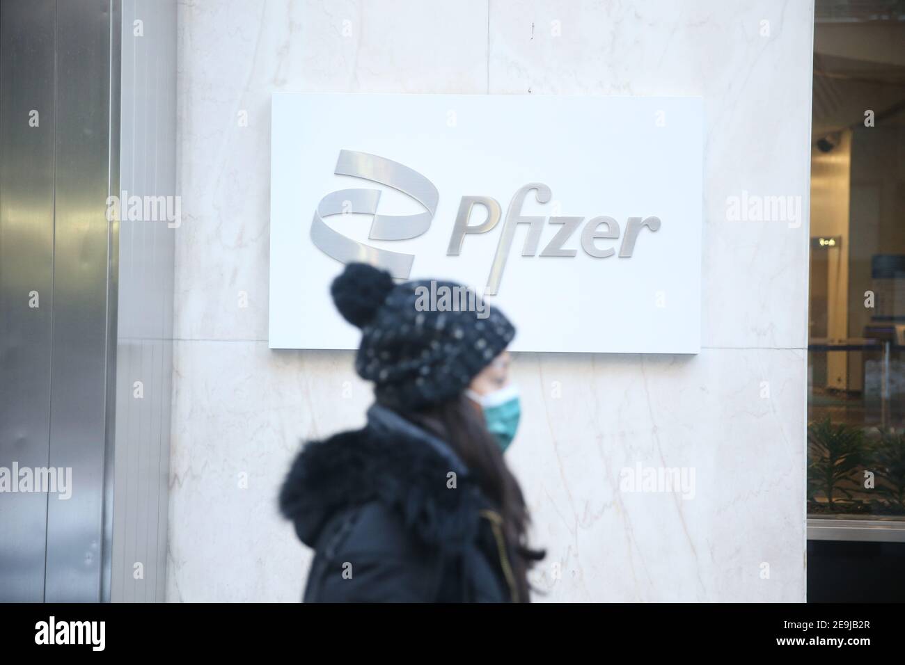 New York City, NY USA une femme passe devant le siège mondial de Pfizer sur la 42e rue à Manhattan Banque D'Images