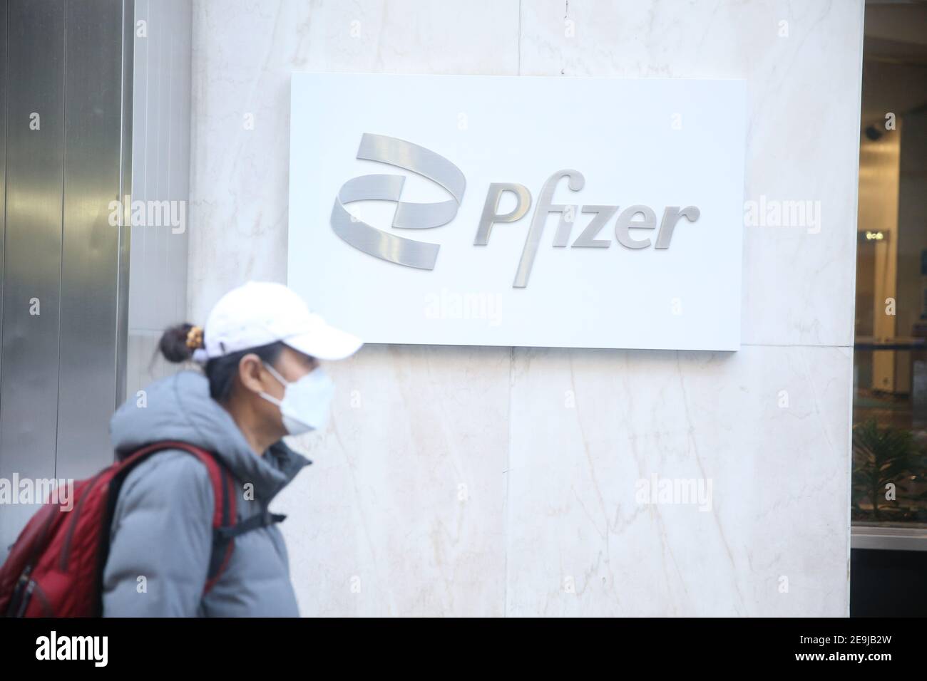 New York City, NY USA une femme passe devant le siège mondial de Pfizer sur la 42e rue à Manhattan Banque D'Images