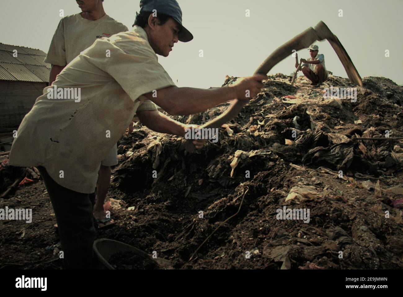 Les hommes qui prennent des matériaux d'un site de décharge de revitalisation de la rivière, pour être utilisés dans la remise en état des terres sur leur environnement de maison. Cilincing, Nord de Jakarta, Jakarta, Indonésie. Banque D'Images
