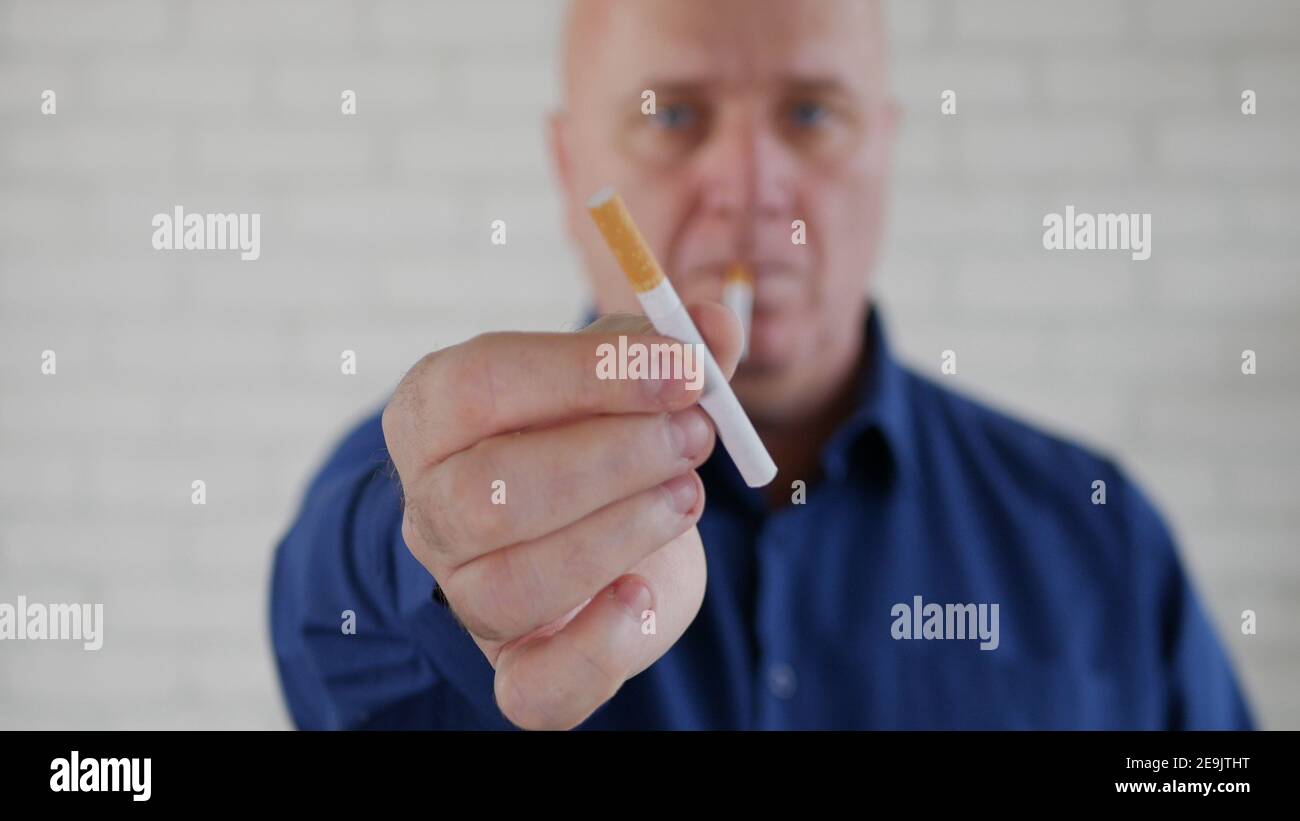 Image avec un homme d'affaires fumant une cigarette. La fumée et la dépendance à la nicotine causent de graves problèmes de santé. Banque D'Images