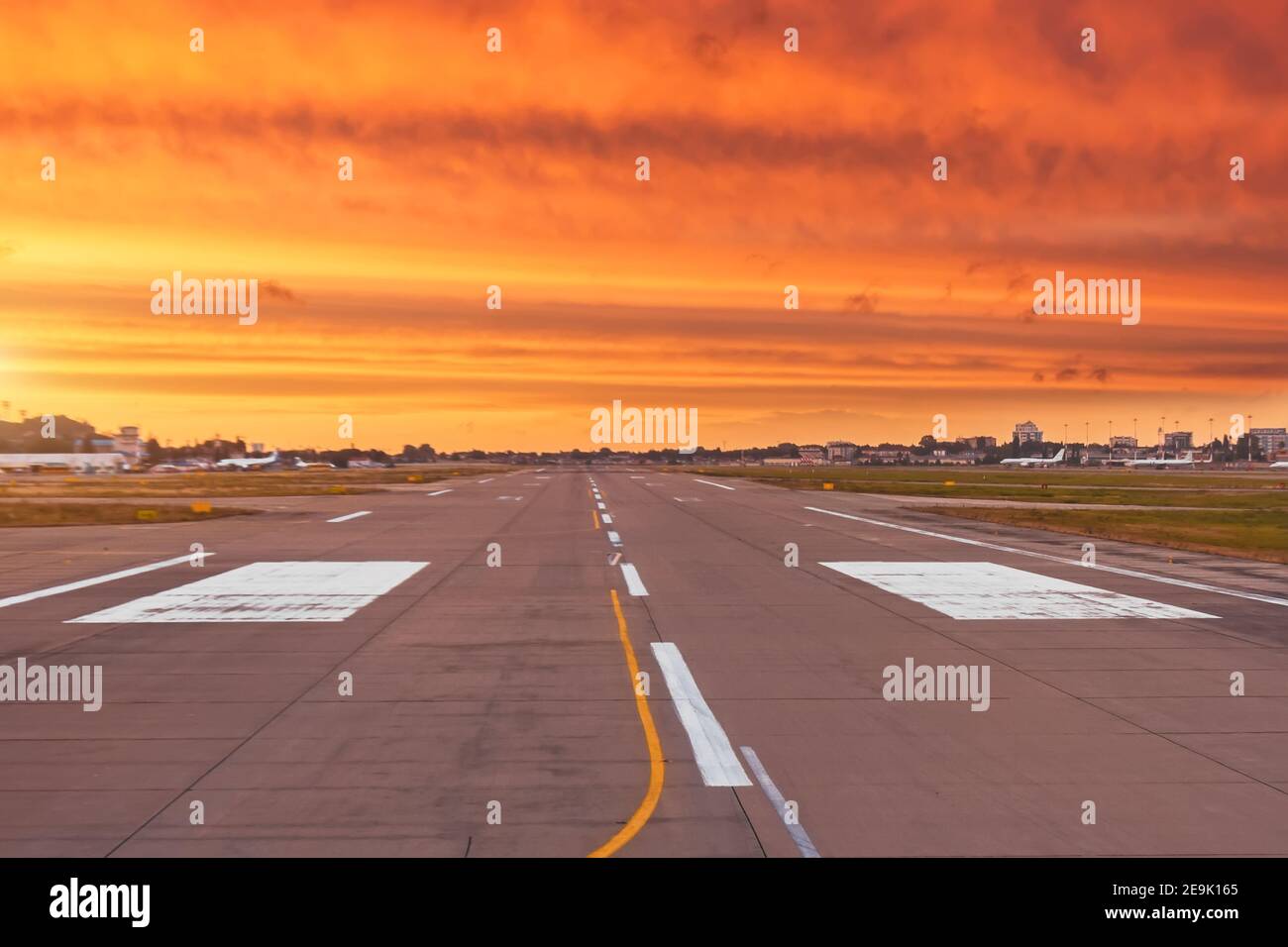 La piste est libre et prête pour le décollage et l'atterrissage de l'avion, sur fond du coucher de soleil le plus lumineux avec les nuages rayés texturés de r Banque D'Images