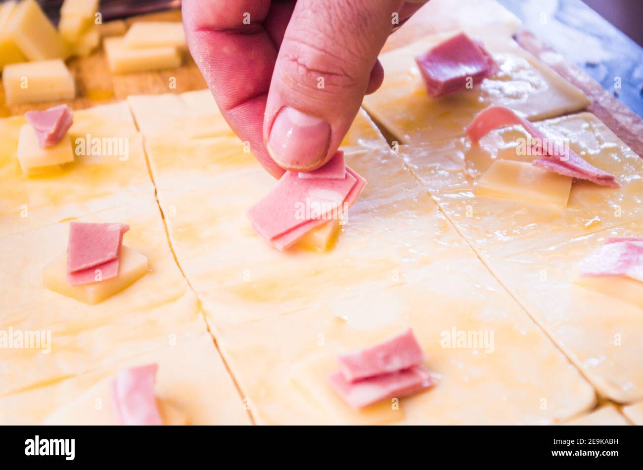 préparation d'en-cas salés faits maison avec pâte feuilletée, mortadelle, fromage et œuf, cuits au four Banque D'Images préparation d'en-cas salés faits maison avec pâte feuilletée, mortadelle, fromage et œuf, cuits au four Banque D'Images