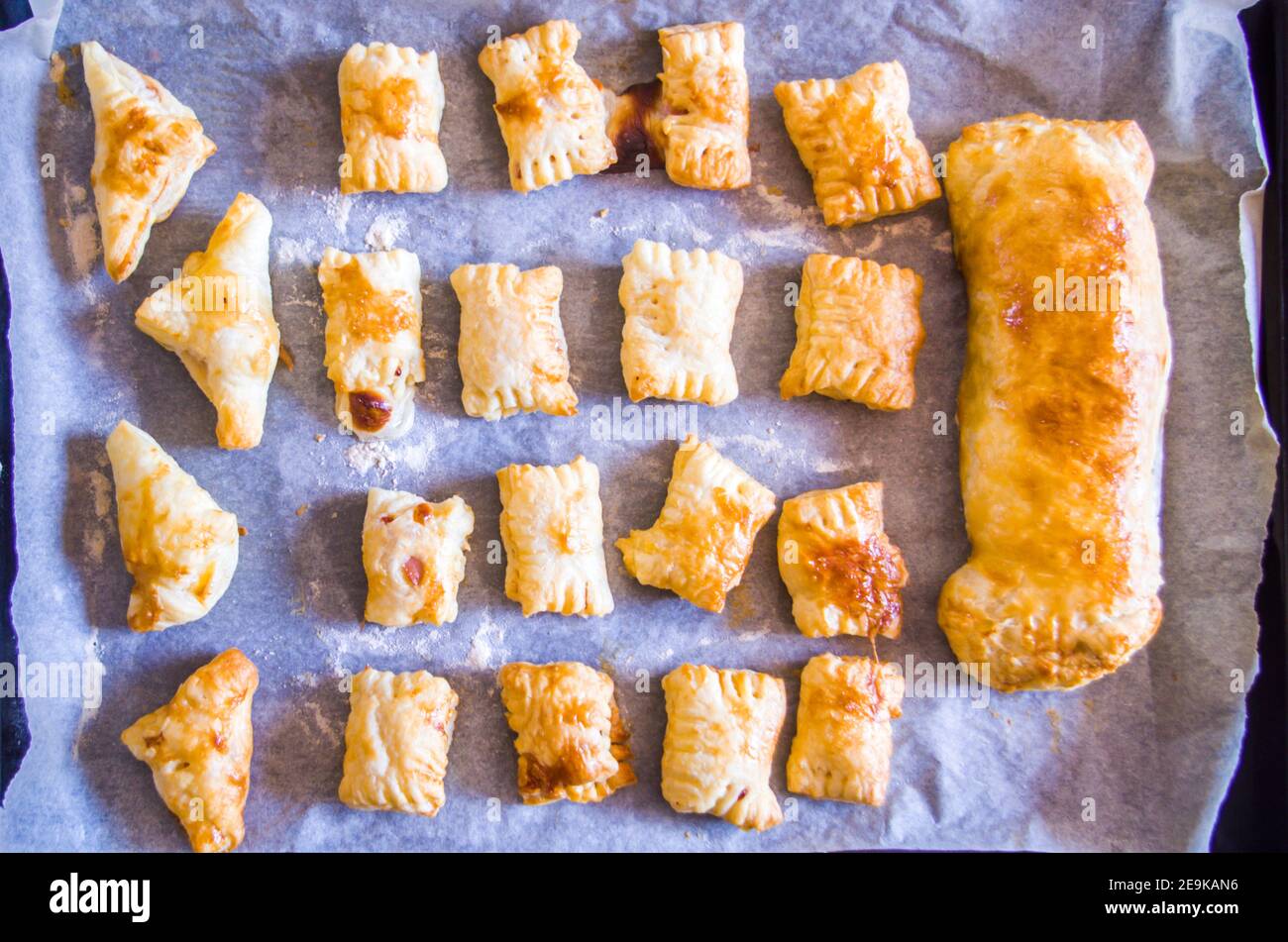 préparation d'en-cas salés faits maison avec pâte feuilletée, mortadelle, fromage et œuf, cuits au four Banque D'Images préparation d'en-cas salés faits maison avec pâte feuilletée, mortadelle, fromage et œuf, cuits au four Banque D'Images