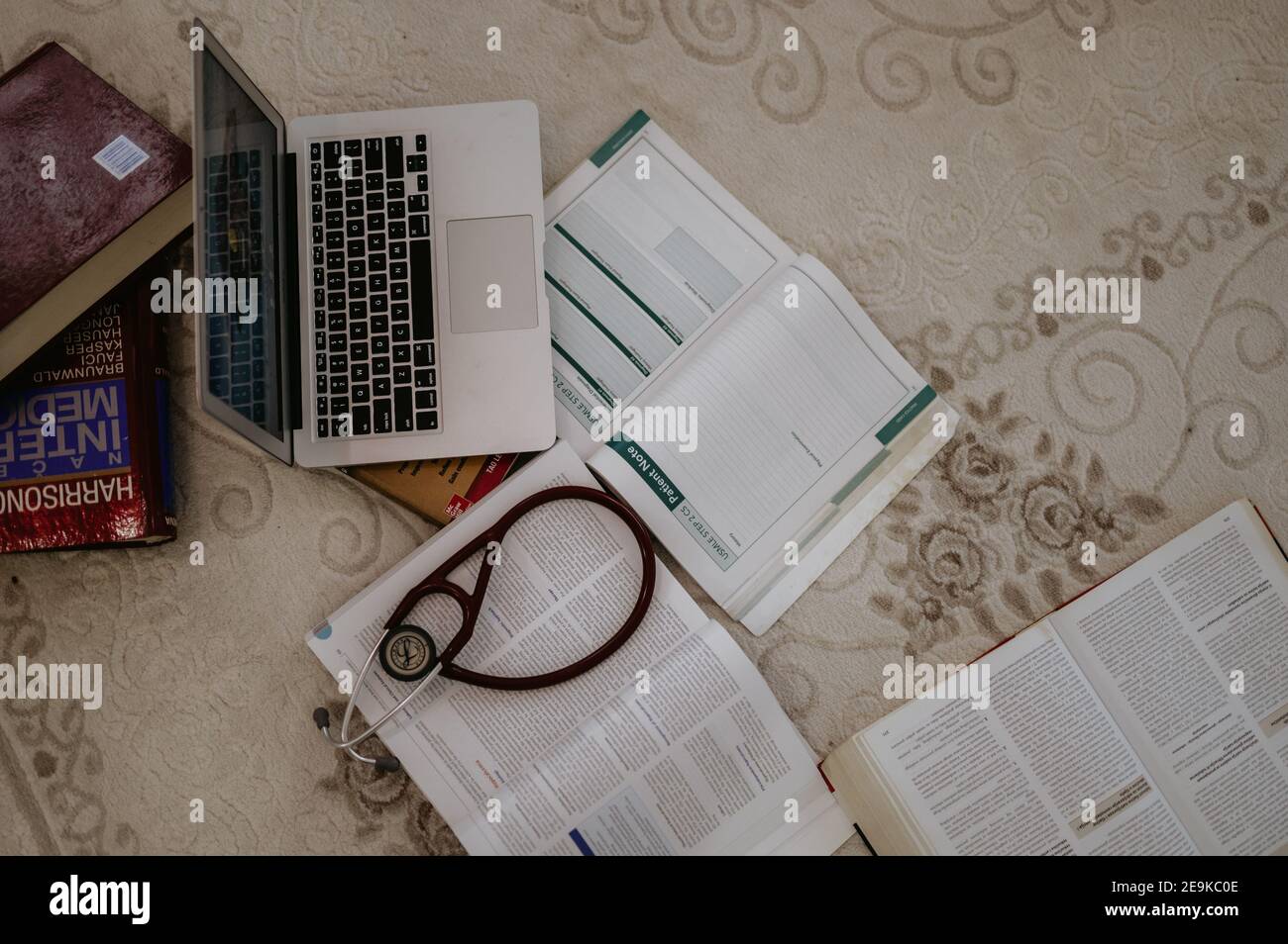 TUZLA, BOSNIE-HERZÉGOVINE - 22 janvier 2020 : manuels d'étudiants en médecine avec ordinateur portable et stéthoscope sur tapis de salle prêts pour l'apprentissage. Banque D'Images