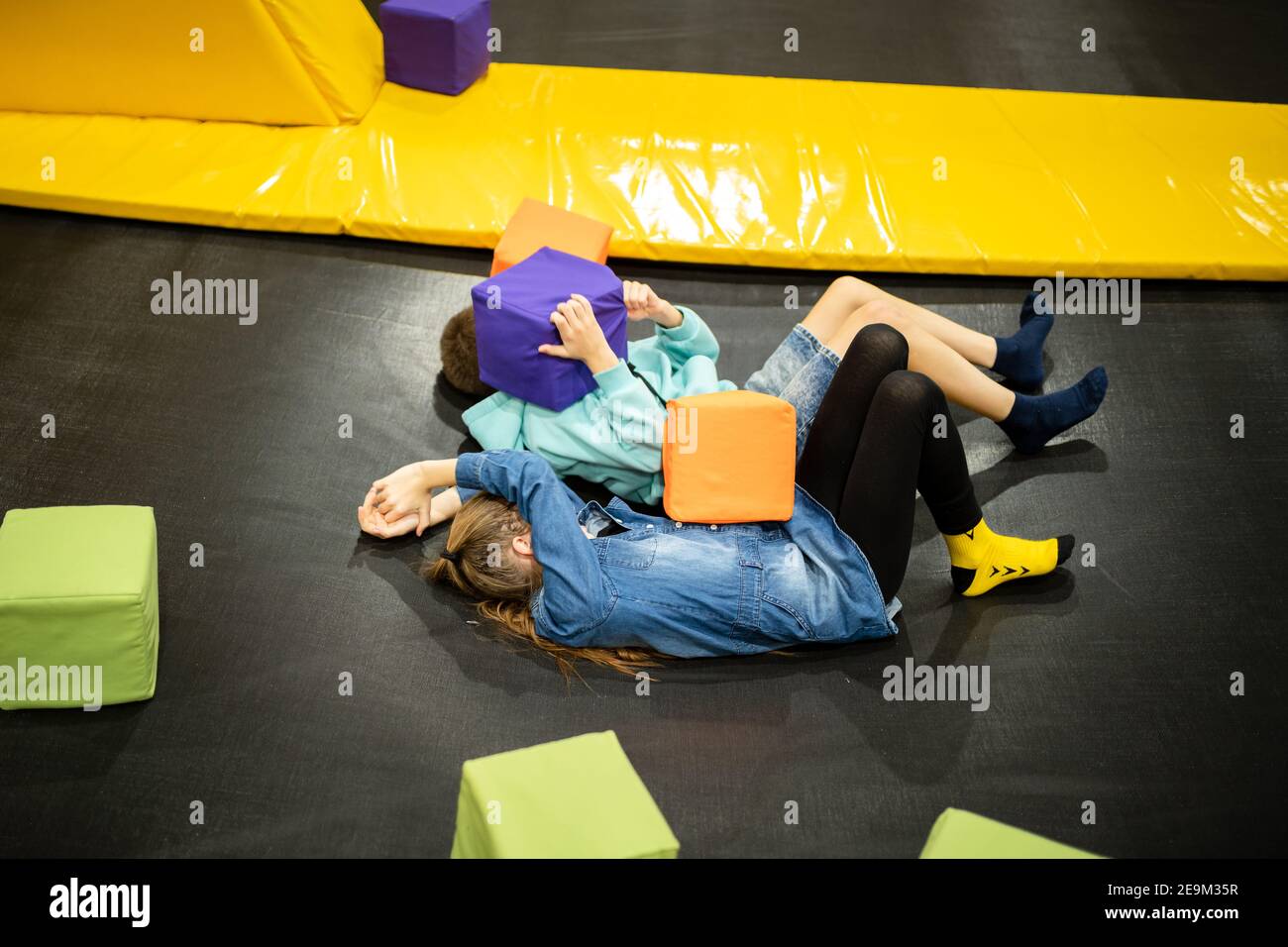 Mignon frère jumeau et soeur sauter et rebondir sur le trampoline intérieur ensemble quand passer du temps dans le centre de jeu d'enfants. Sports et divertissements Banque D'Images