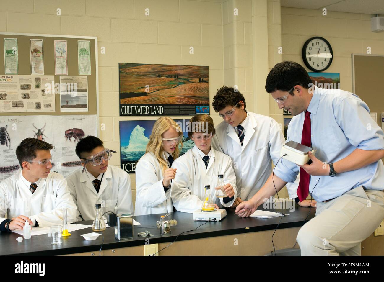 les adolescents d'un cours de sciences étant instruisant par un enseignant Banque D'Images