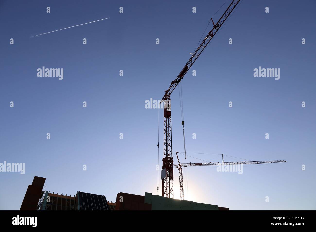 Chantier de construction avec grues à la tombée de la nuit Banque D'Images