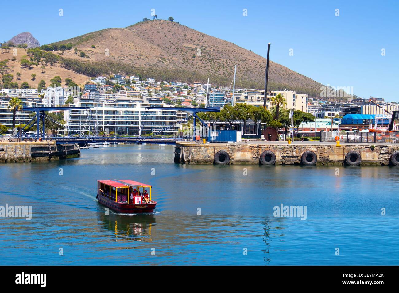 Front de mer- Cape Town, Afrique du Sud - 03-02-2021 vue imprenable sur le ferry Red Penny flottant sur l'eau, la montagne et le pont traversant. Banque D'Images