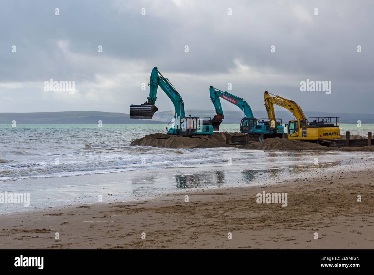 Machinerie lourde travaillant sur le programme de renouvellement de l'aine de bois qui se déroule sur la plage à Alum Chine, Bournemouth, Dorset, Royaume-Uni, en février Banque D'Images