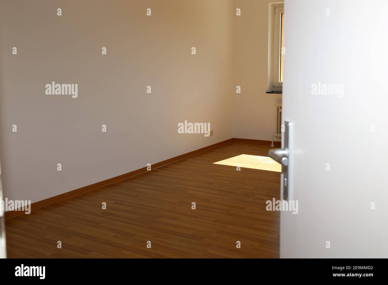 Image de symbole : porte à moitié ouverte dans un appartement vide Banque D'Images