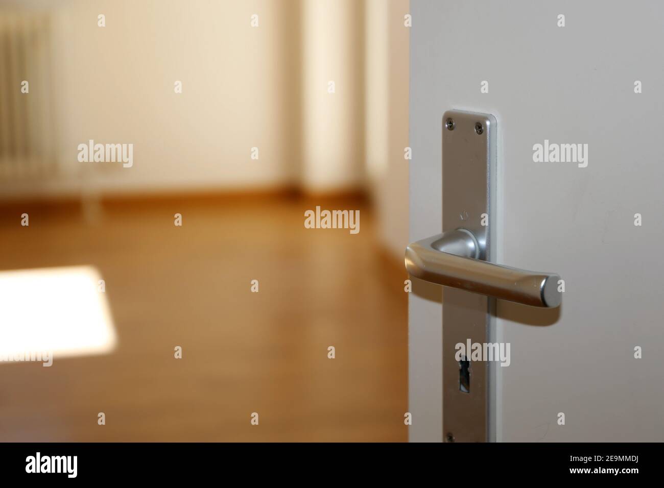 Image de symbole : porte à moitié ouverte dans un appartement vide Banque D'Images