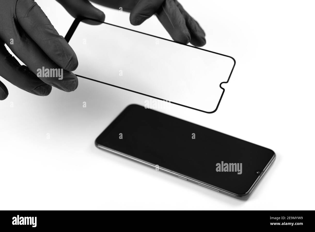 Un homme est l'installation d'une vitre de protection sur l'écran d'un smartphone. Banque D'Images