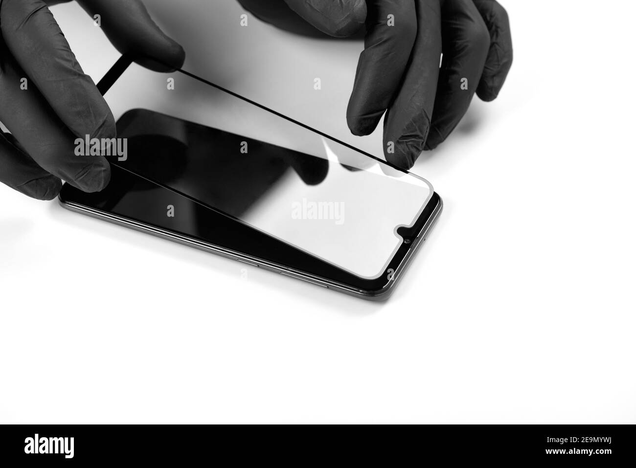 Un homme est l'installation d'une vitre de protection sur l'écran d'un smartphone. Banque D'Images