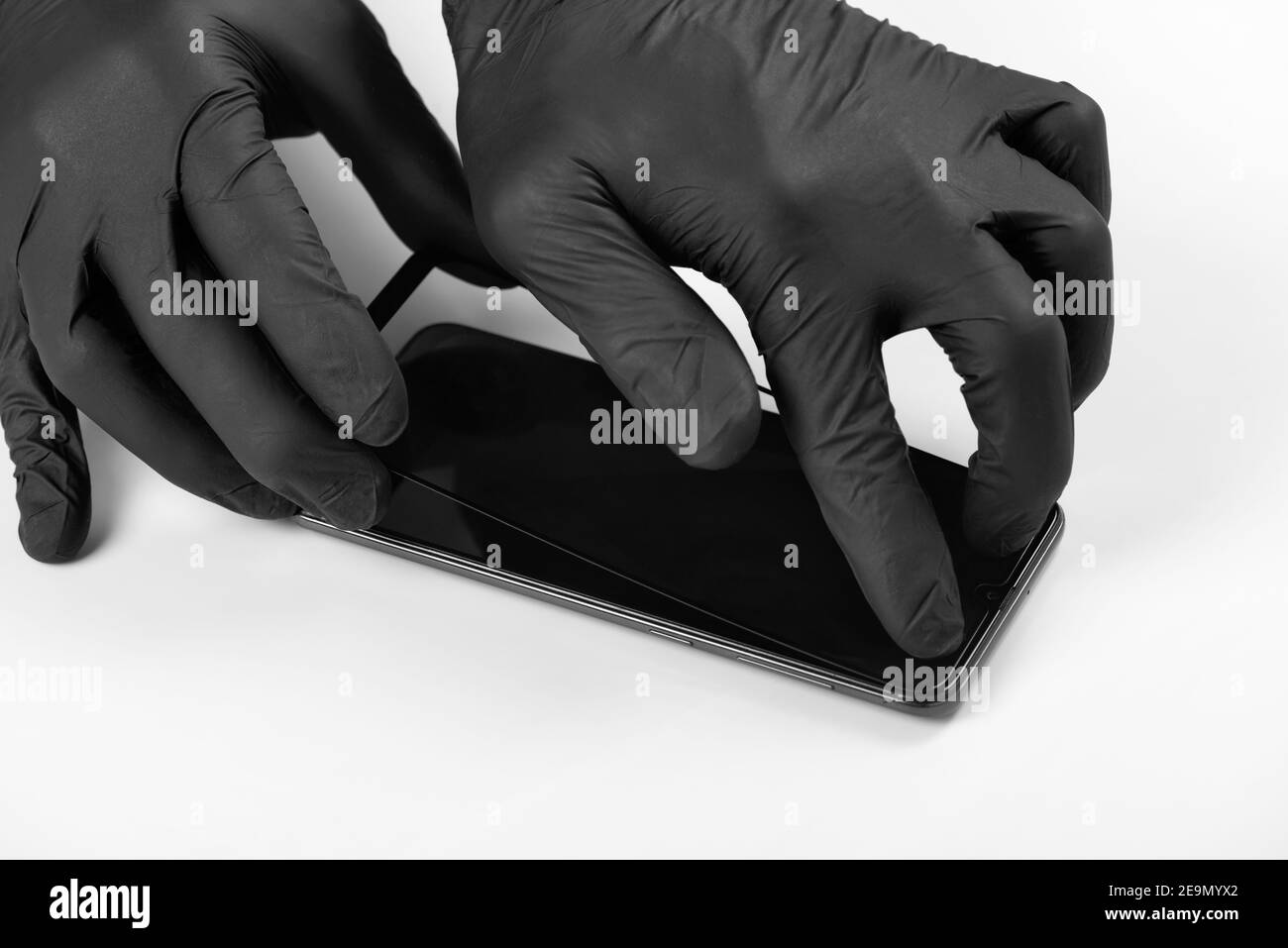 Un homme est l'installation d'une vitre de protection sur l'écran d'un smartphone. Banque D'Images