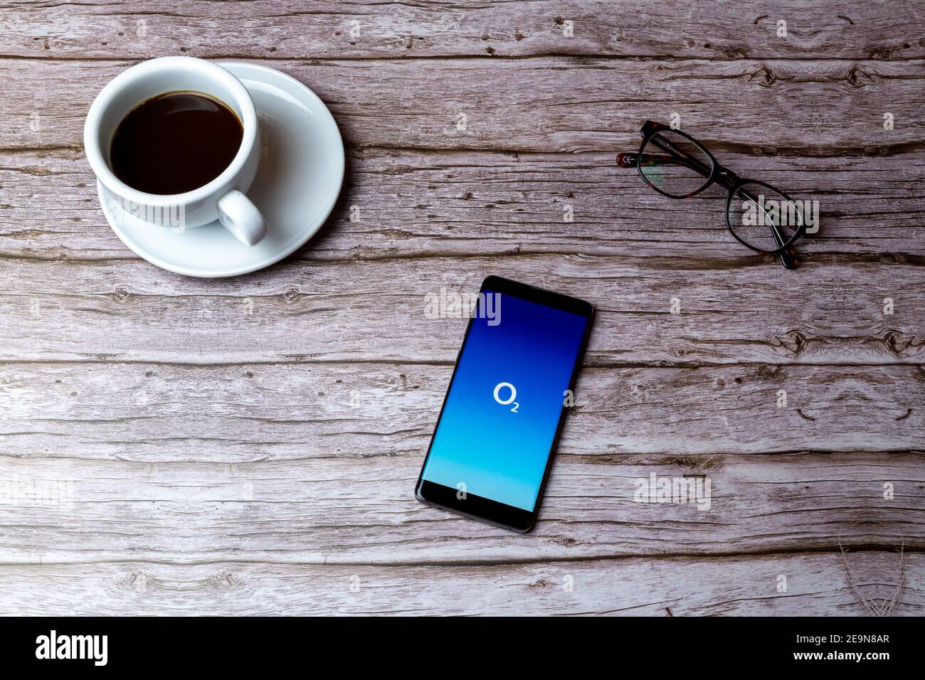 Un téléphone portable ou mobile posé sur un bois Table ou bureau avec l'application O2 Phone ouverte Banque D'Images