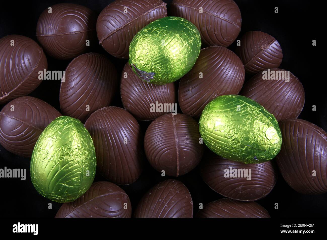Pile de citron vert ou jaune enveloppé d'aluminium et les oeufs de pâques en chocolat emballé sur un fond noir. Banque D'Images