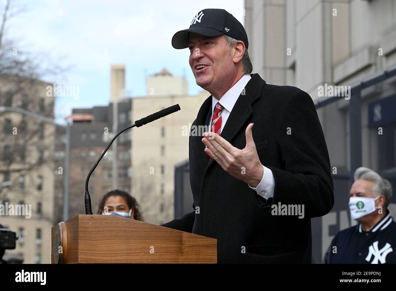 Bill de Blasio, maire de New York, sourit alors qu'il annonce une casquette  de baseball des New York Yankees lors d'une conférence de presse pour  annoncer l'ouverture d'un centre de vaccination COVID-19