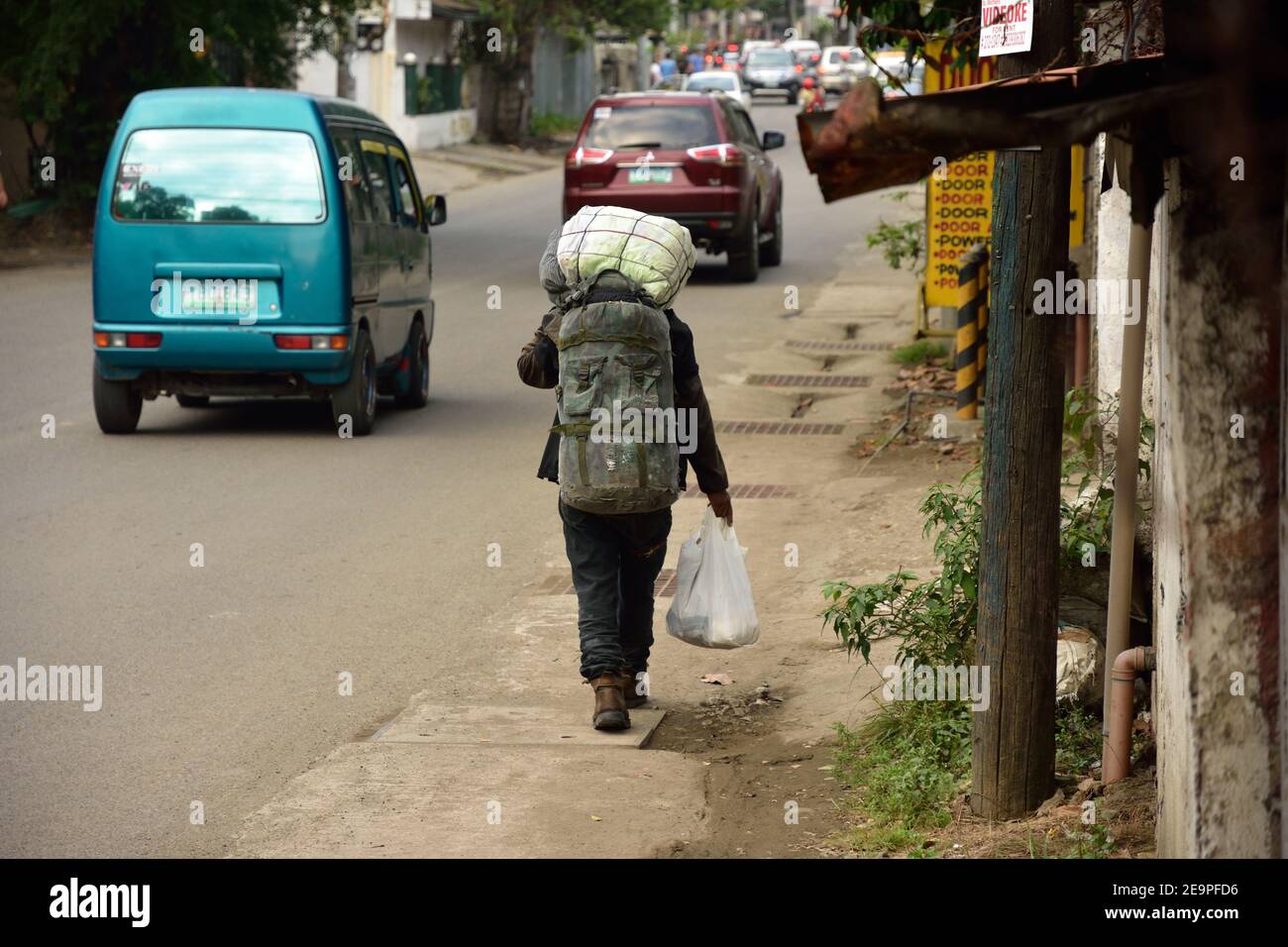 Le travailleur porte un sac sur sa tête à la maison. Fin de la journée de travail, dur travail aux philippines, en asie Banque D'Images