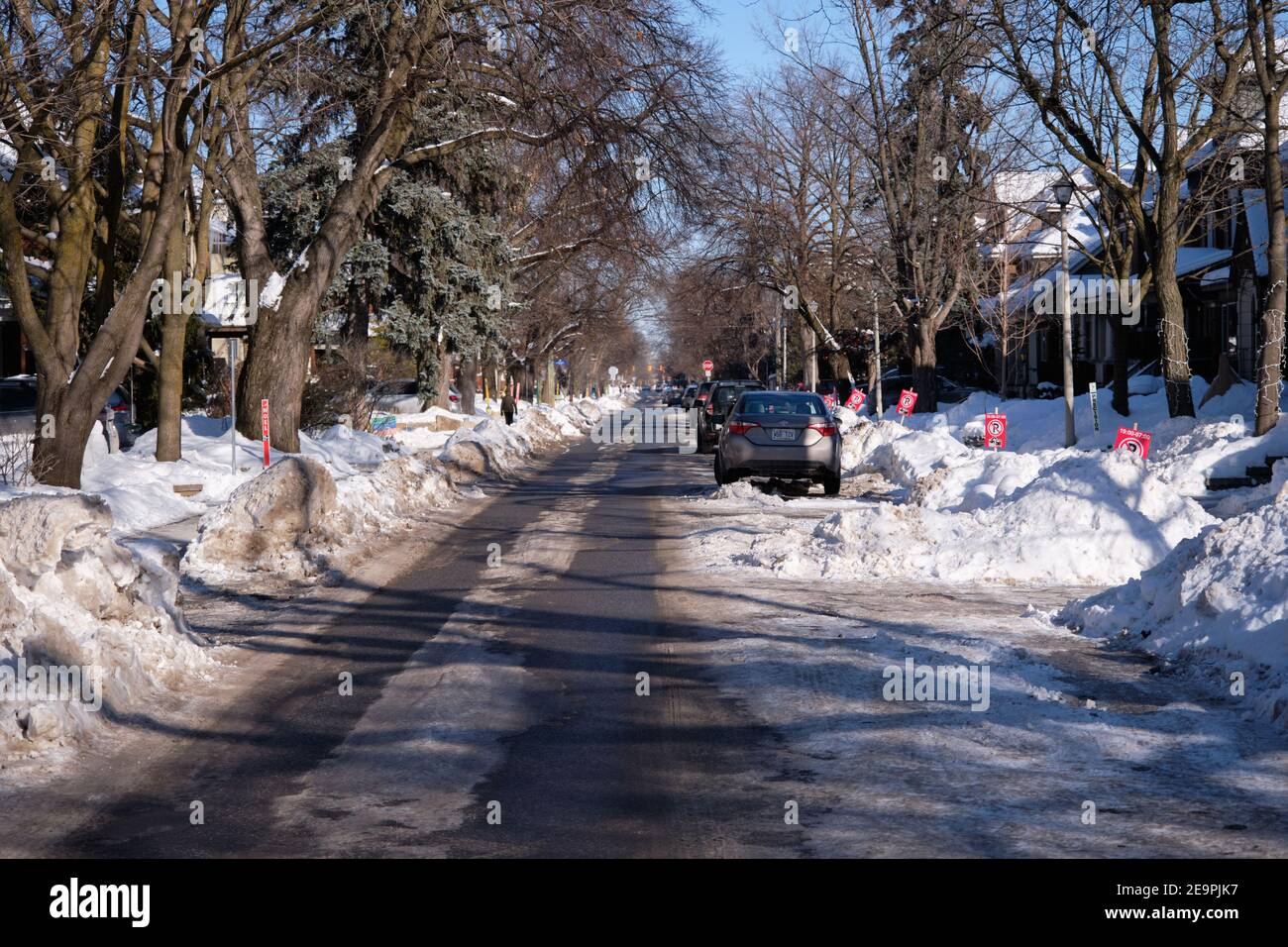 Rue de la ville d'Ottawa avec des voitures garées au milieu de la route à cause des bancs de neige, ne laissant qu'une seule voie Banque D'Images