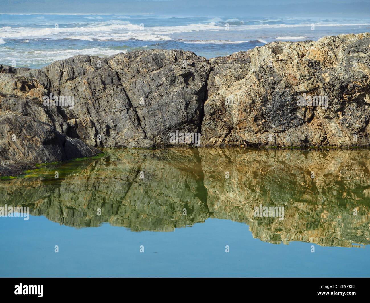 De magnifiques reflets. Les rochers bordant la piscine se réfléchit et se reflétaient dans l'eau salée, en regardant au-delà de l'océan Pacifique. Clarté Banque D'Images