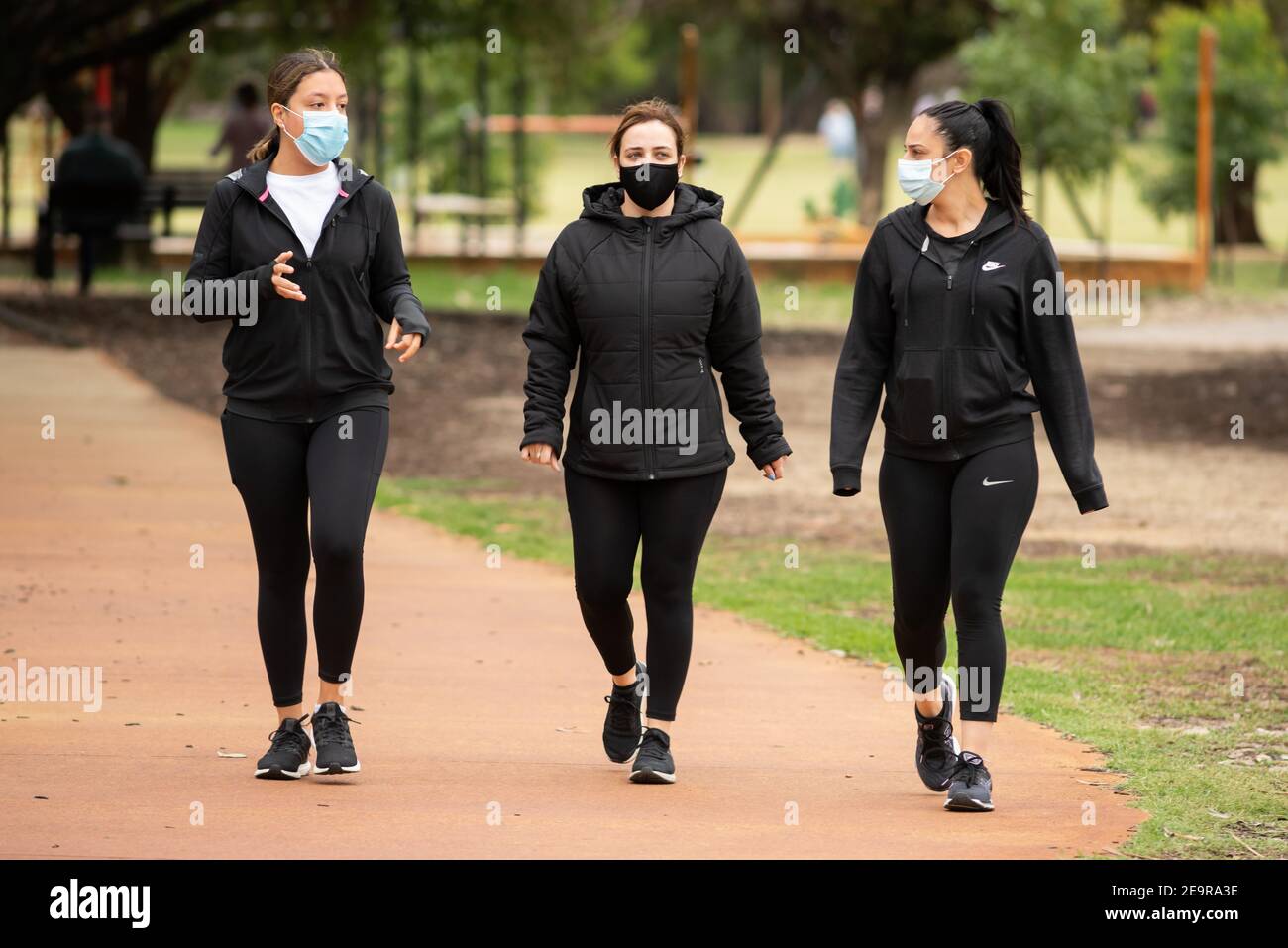Les filles marchant avec des masques le premier jour suivant la levée d'un « verrouillage » de cinq jours lié à la COVID à Perth, en Australie occidentale Banque D'Images