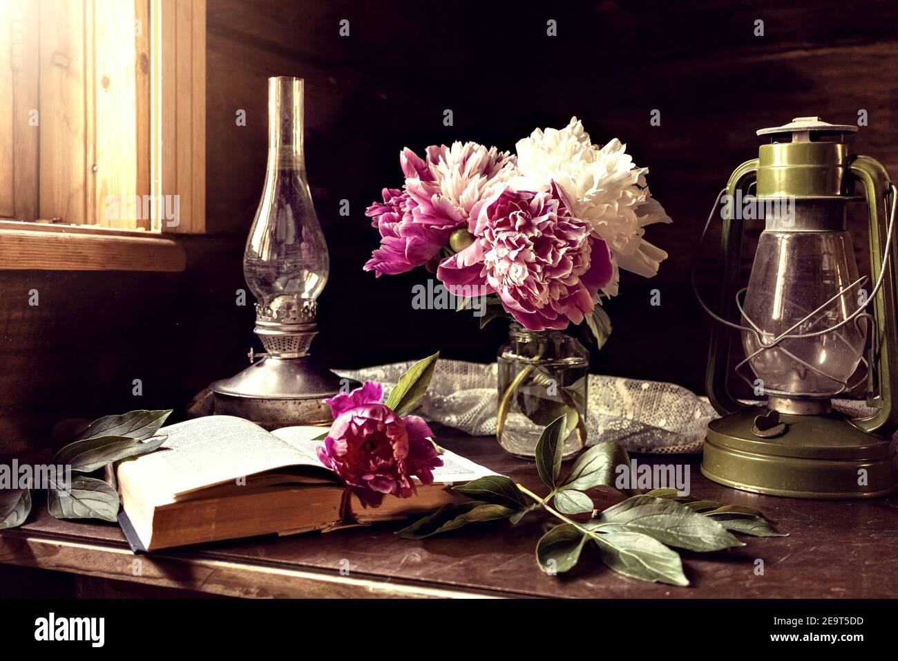 Encore la vie d'articles vintage et un bouquet de pivoines sur une table près de la fenêtre dans un vieux village maison Banque D'Images
