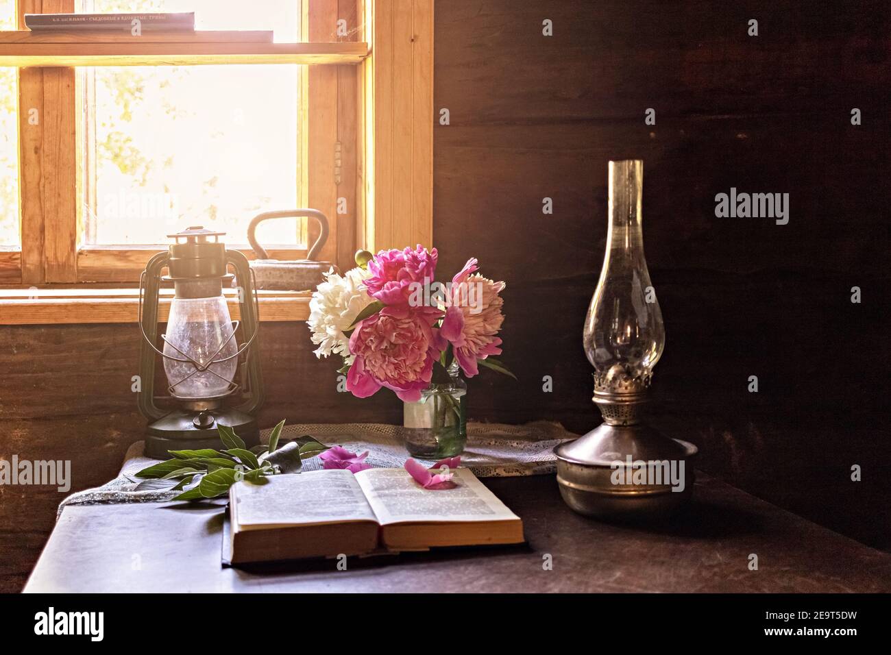 Encore la vie d'articles vintage et un bouquet de pivoines sur une table près de la fenêtre dans un vieux village maison Banque D'Images