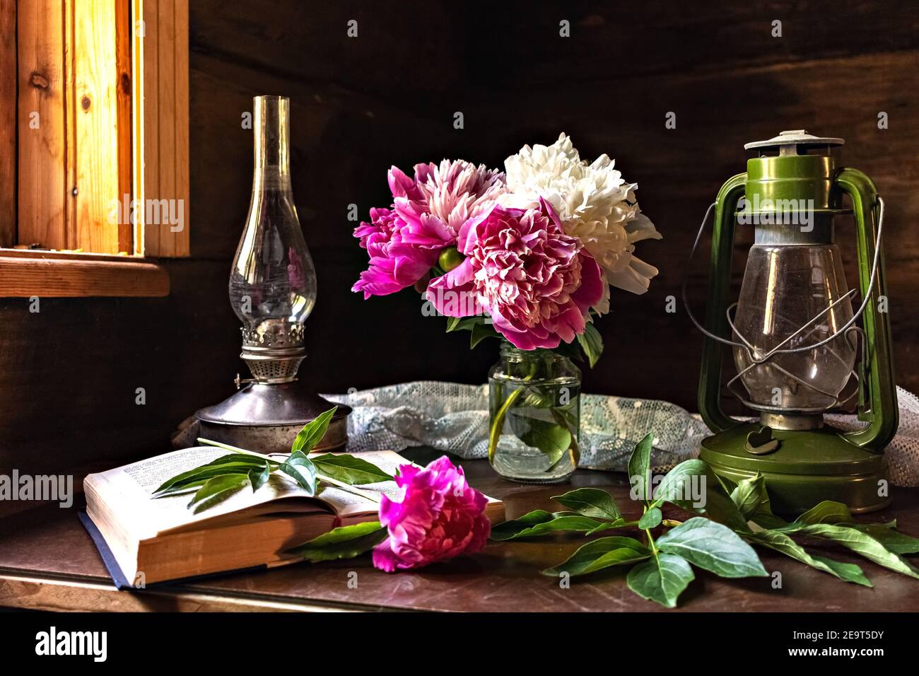 Encore la vie d'articles vintage et un bouquet de pivoines sur une table près de la fenêtre dans un vieux village maison Banque D'Images