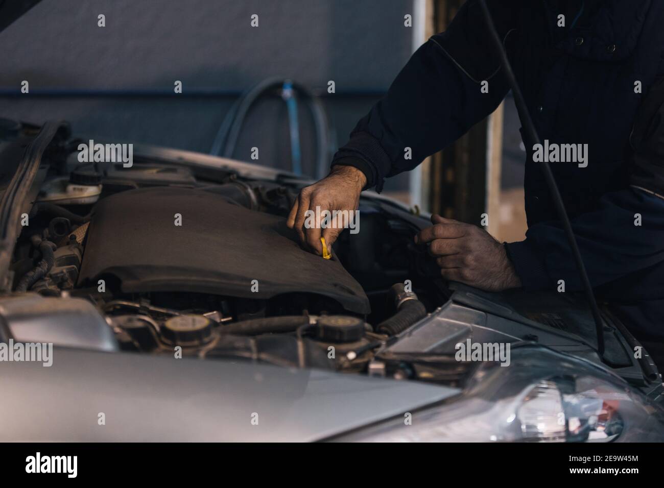 Close up d'un mécanicien de voiture de vérifier le niveau d'huile dans un atelier de mécanique Banque D'Images
