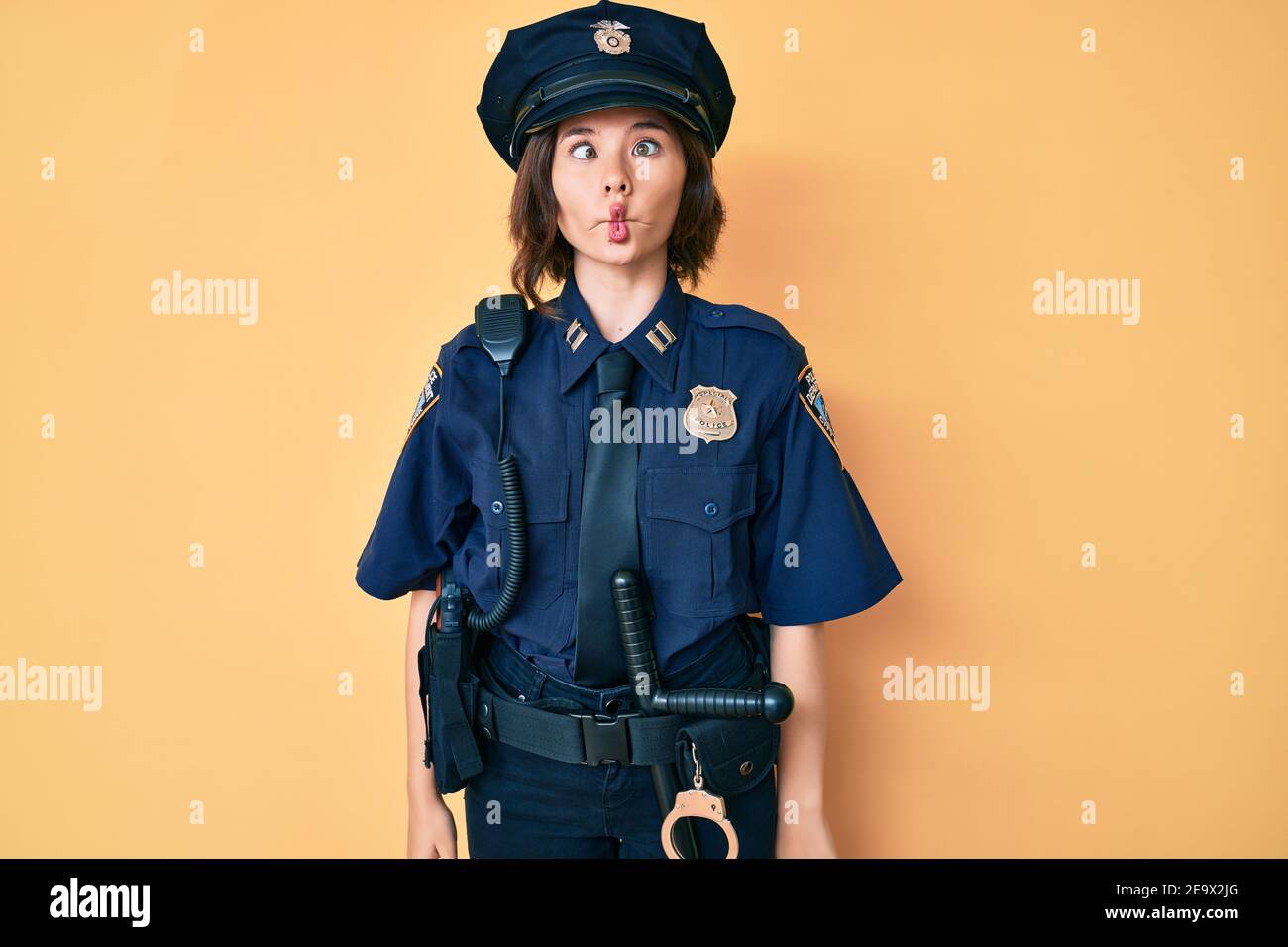 Jeune belle femme portant l'uniforme de police faisant le visage de poisson  avec les lèvres, fou et geste comique. Expression drôle Photo Stock - Alamy