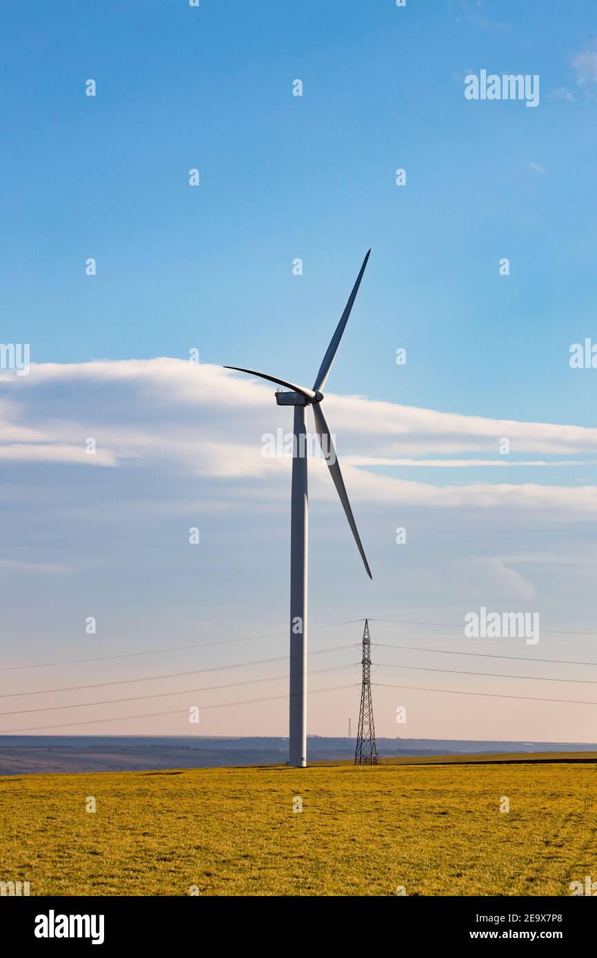 Beau paysage lumineux avec un Windfarm par une journée ensoleillée avec un ciel plein de nuages et coloré premier plan avec herbe vert-jaunâtre Banque D'Images