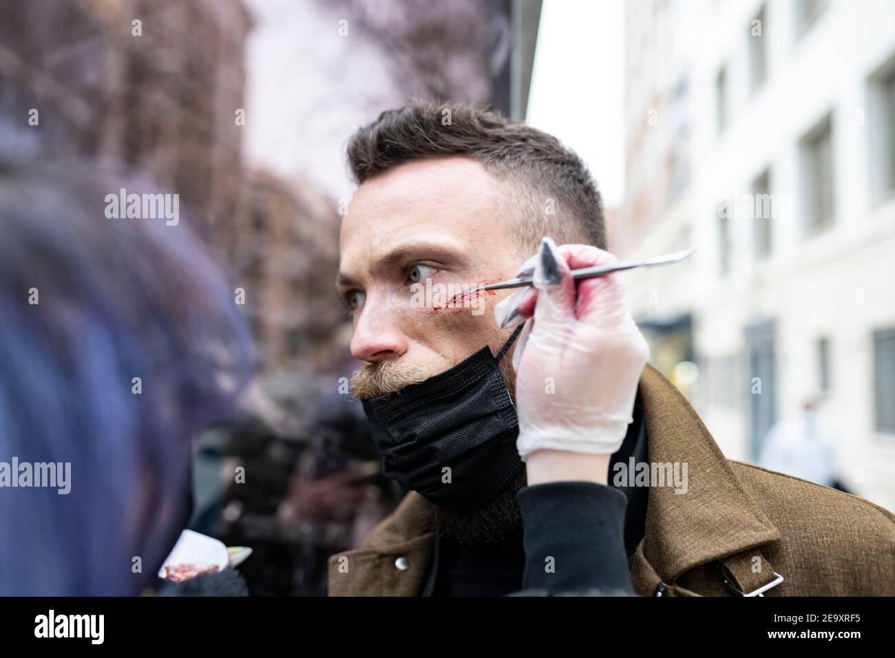 Gros plan d'un maquilleur méconnaissable qui met du maquillage sur un taille basse visage de l'homme Banque D'Images